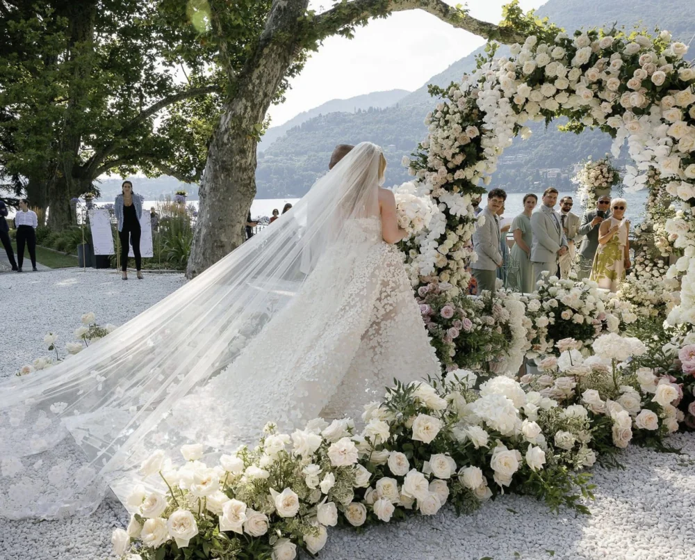 A bride and groom walking down a candlelit aisle